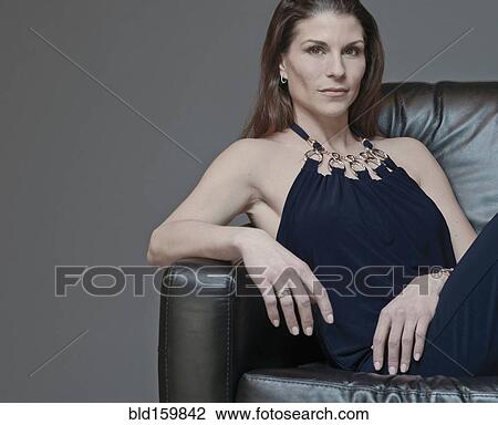 Mixed race woman in evening gown sitting in armchair View Large Photo Image Stock Image - Mixed race woman in evening gown sitting in armchair. Fotosearch