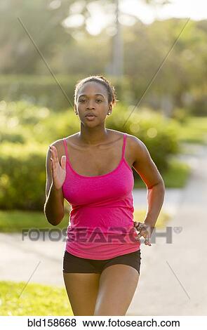 Mixed race woman jogging on suburban sidewalk View Large Photo Image Stock Photo - Mixed race woman jogging on suburban sidewalk. Fotosearch