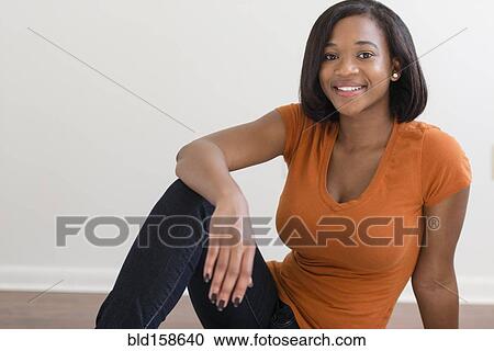 Stock Image - Mixed race woman smiling on floor. Fotosearch
