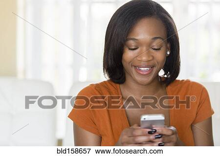 Stock Photo - Mixed race woman using cell phone. Fotosearch