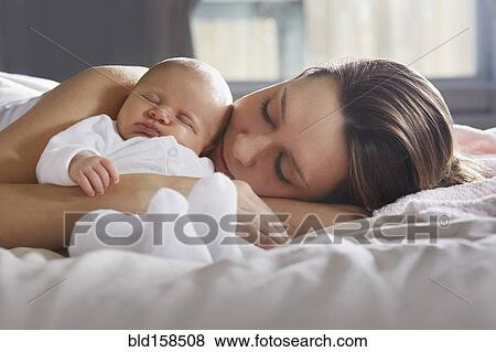 Mother hugging newborn baby on bed View Large Photo Image Stock Photo - Mother hugging newborn baby on bed. Fotosearch