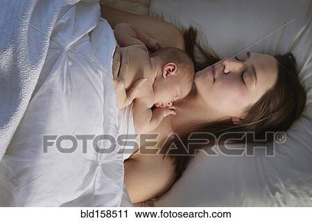 Mother sleeping with newborn baby on bed View Large Photo Image Stock Image - Mother sleeping with newborn baby on bed. Fotosearch