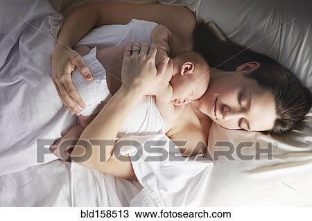 Mother sleeping with newborn baby on bed View Large Photo Image Stock Image - Mother sleeping with newborn baby on bed. Fotosearch
