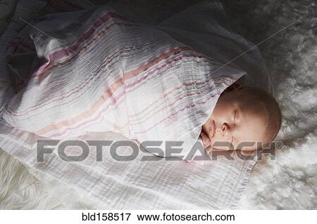 Stock Photo - Newborn baby swaddled in blanket. Fotosearch