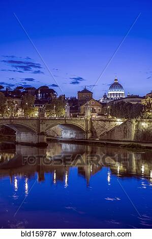 Stock Photo - Ornate buildings and bridge illuminated at night, Rome, Italy. Fotosearch