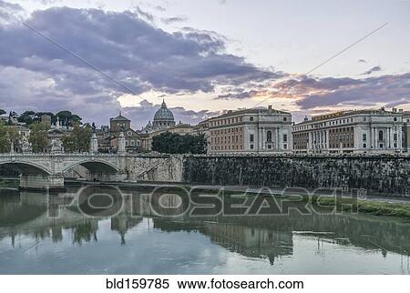 Stock Photography - Ornate buildings and bridge reflecting in still river, Rome, Italy. Fotosearch