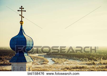 Stock Photograph - Ornate church spire over rural landscape. Fotosearch