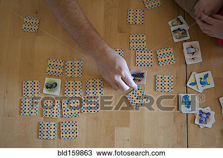 Stock Image - People playing tile game on wooden table. Fotosearch