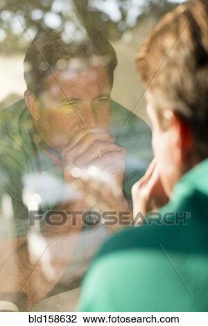Stock Image - Reflection of Caucasian nurse in window. Fotosearch