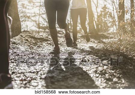 Runners jogging on dirt path View Large Photo Image Stock Photo - Runners jogging on dirt path. Fotosearch