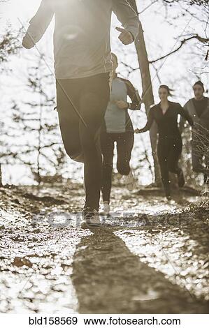 Runners jogging on dirt path View Large Photo Image Stock Photo - Runners jogging on dirt path. Fotosearch