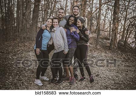 Stock Image - Runners smiling on forest path. Fotosearch