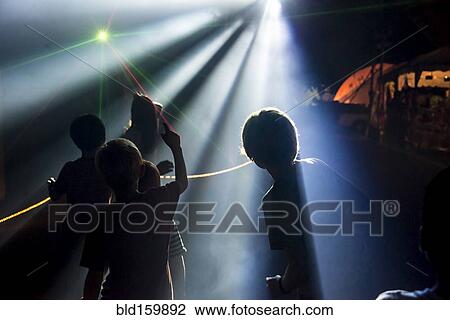 Silhouette of children under spotlights at night View Large Photo Image Stock Image - Silhouette of children under spotlights at night. Fotosearch