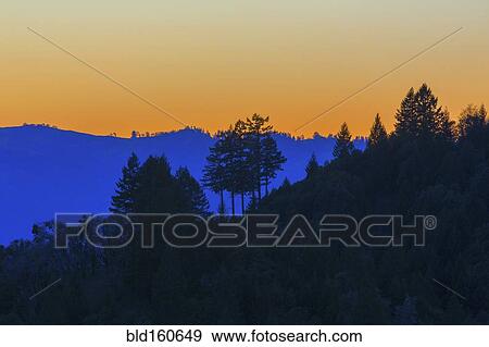 Stock Photo - Silhouette of remote hills under sunset sky. Fotosearch