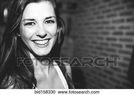 Stock Image - Smiling Caucasian woman laughing in nightclub. Fotosearch