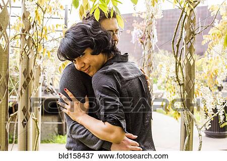 Stock Photo - Smiling couple hugging in park. Fotosearch