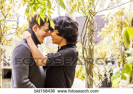 Smiling couple rubbing noses in park View Large Photo Image Stock Photograph - Smiling couple rubbing noses in park. Fotosearch
