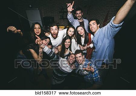 Stock Photo - Smiling friends posing in nightclub. Fotosearch