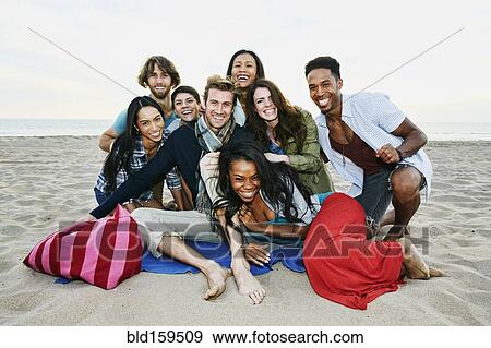 Stock Photo - Smiling friends posing on beach. Fotosearch