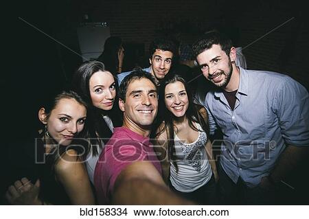 Smiling friends taking selfie in nightclub View Large Photo Image Picture - Smiling friends taking selfie in nightclub. Fotosearch