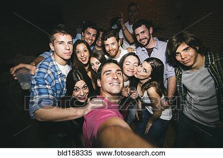 Stock Photography - Smiling friends taking selfie in nightclub. Fotosearch