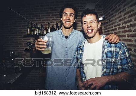 Stock Image - Smiling men drinking in nightclub. Fotosearch