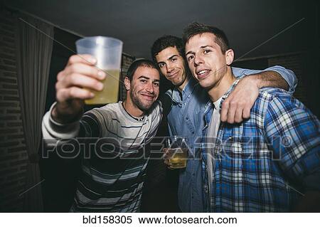 Stock Photography - Smiling men drinking in nightclub. Fotosearch