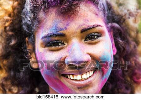 Stock Photography - Smiling mixed race woman covered in pigment powder. Fotosearch