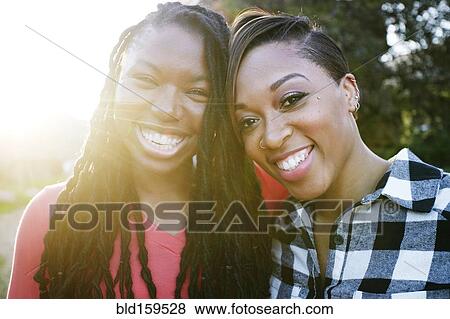 Smiling women hugging outdoors View Large Photo Image Stock Photo - Smiling women hugging outdoors. Fotosearch