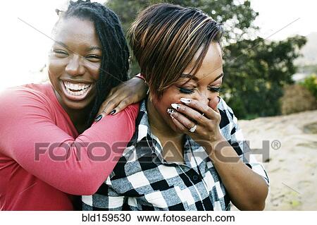 Stock Image - Smiling women laughing outdoors. Fotosearch