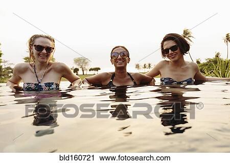 Smiling women relaxing in infinity pool View Large Photo Image Stock Image - Smiling women relaxing in infinity pool. Fotosearch
