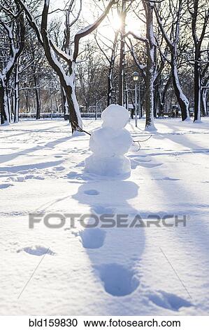 Snowman and footprints in snowy park View Large Photo Image Stock Image - Snowman and footprints in snowy park. Fotosearch