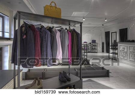 Stock Photo - Suits and shoes on rack in clothing store for men. Fotosearch
