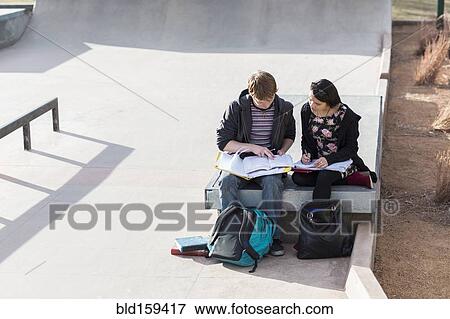 Stock Photo - Teenage students studying in skateboard park. Fotosearch