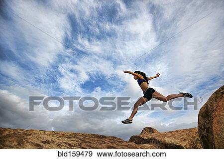Stock Photo - Vietnamese woman running in rocky field. Fotosearch