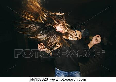 Woman tossing her hair and dancing in nightclub View Large Photo Image Stock Photograph - Woman tossing her hair and dancing in nightclub. Fotosearch