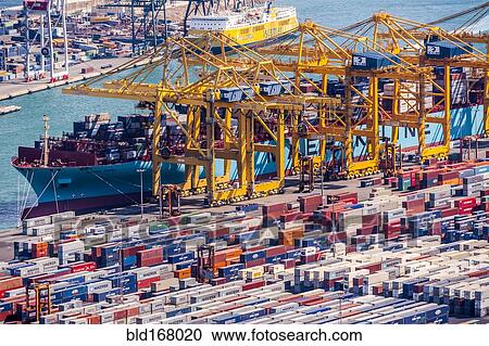 Stock Image - Aerial view of cranes and containers in urban shipyard. Fotosearch