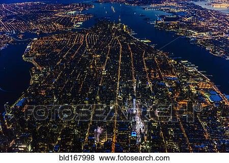 Stock Photo - Aerial view of Manhattan cityscape and river at night, New York, United States. Fotosearch