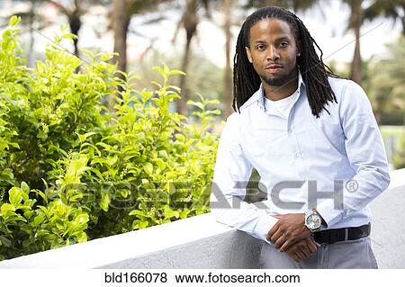 Stock Photo - African American businessman standing outdoors. Fotosearch