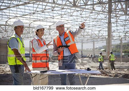 Architects talking at construction site View Large Photo Image Stock Photo - Architects talking at construction site. Fotosearch