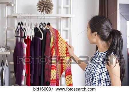 Asian woman shopping in clothing store View Large Photo Image Stock Photo - Asian woman shopping in clothing store. Fotosearch