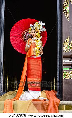 Stock Photo - Asian woman standing in ornate temple doorway, Chiang Mai, Chiang Mai, Thailand. Fotosearch