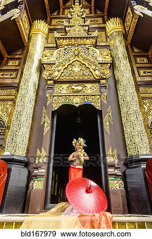 Stock Photo - Asian woman standing in ornate temple doorway, Chiang Mai, Chiang Mai, Thailand. Fotosearch