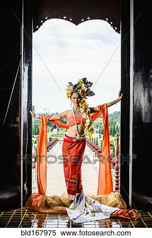 Stock Photography - Asian woman standing in ornate temple doorway, Chiang Mai, Chiang Mai, Thailand. Fotosearch
