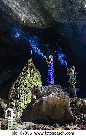 Asian women burning incense on rock formation in cave temple View Large Photo Image Stock Photography - Asian women burning incense on rock formation in cave temple. Fotosearch