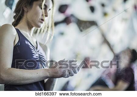 Athlete chalking her hands at rock wall in gym View Large Photo Image Stock Photo - Athlete chalking her hands at rock wall in gym. Fotosearch