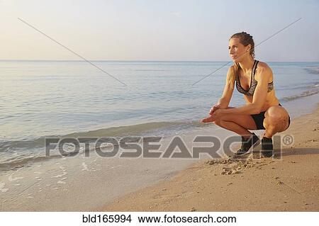 Athlete crouching on beach View Large Photo Image Picture - Athlete crouching on beach. Fotosearch