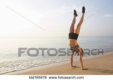 Athlete doing handstand on beach View Large Photo Image Stock Photo - Athlete doing handstand on beach. Fotosearch