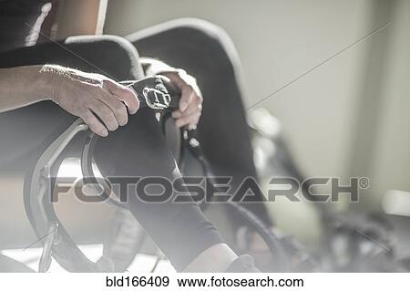 Stock Photo - Athlete fastening climbing harness in gym. Fotosearch
