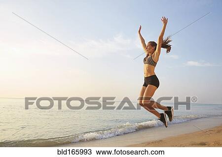 Athlete jumping for joy on beach View Large Photo Image Stock Image - Athlete jumping for joy on beach. Fotosearch